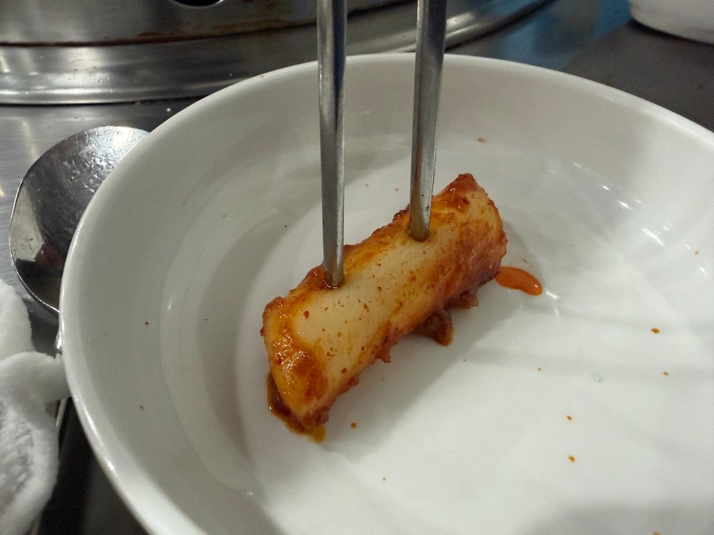 Tteokbokki rice cakes cooking on a dakgalbi griddle