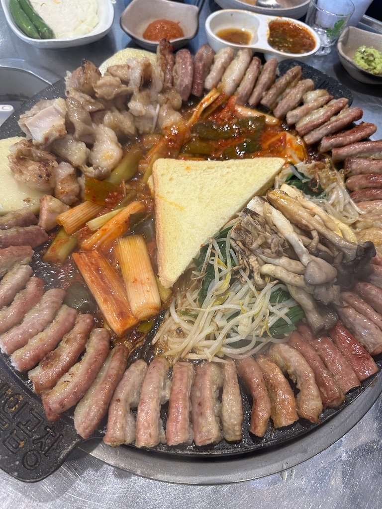 Neatly arranged beef gopchang and vegetables on a grill before cooking