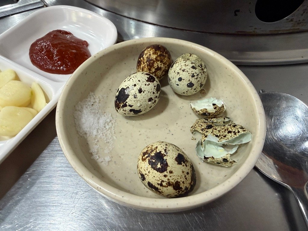Basic banchan side dishes including quail eggs and pickled cucumber