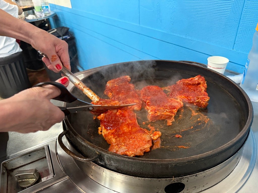 Chicken and cabbage being stir-fried on a dakgalbi griddle