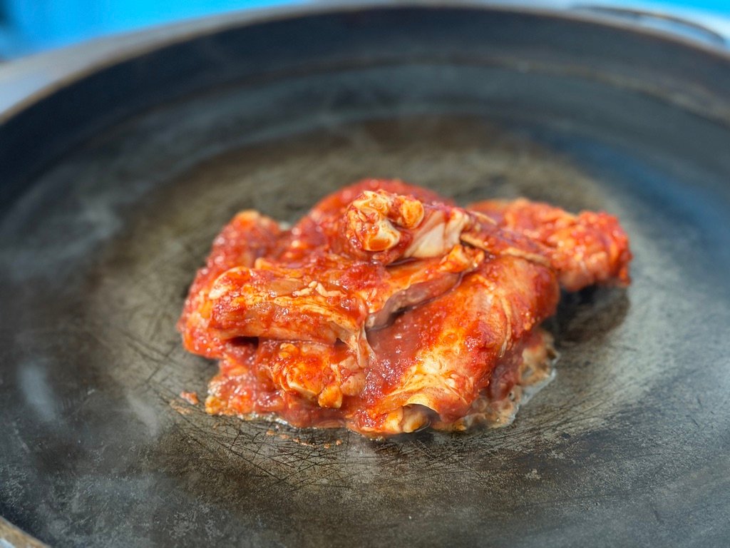 Staff member grilling dakgalbi at the table