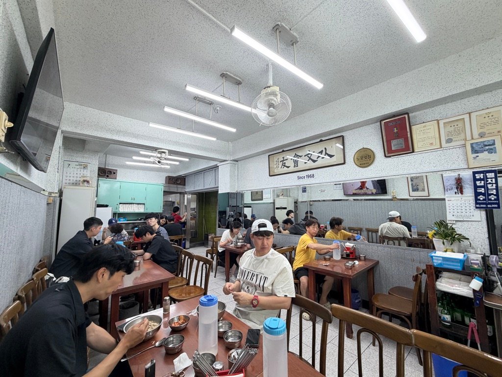 Interior of Hyeseong Kalguksu with regulars seated at wooden tables