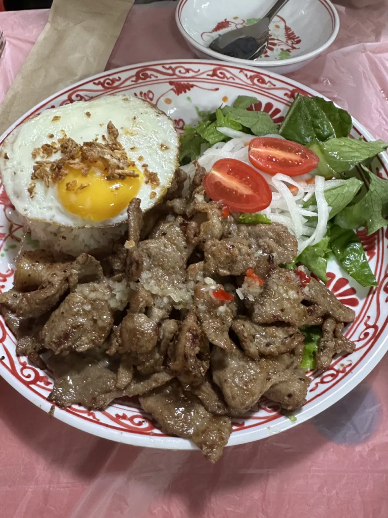 Rice plate with grilled pork, fried egg, and side salad at Bun Cha Kim