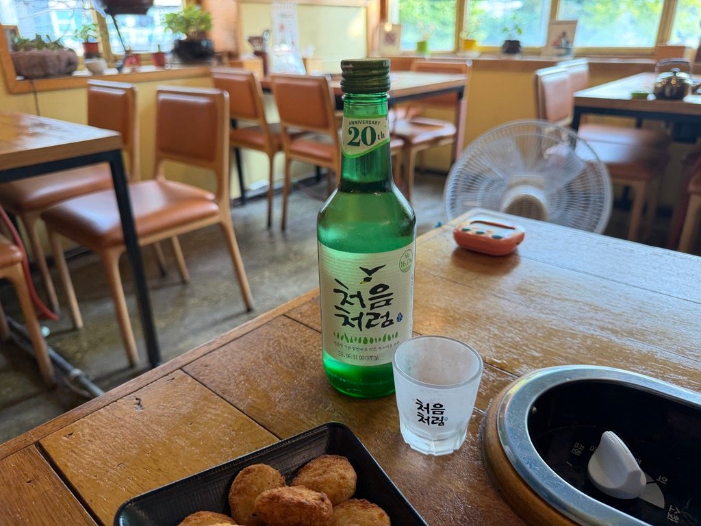 Glass of soju poured to pair with spicy budae-jjigae