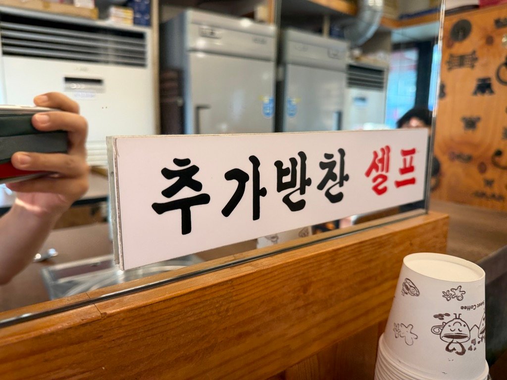 Sign indicating self-serve extra side dishes