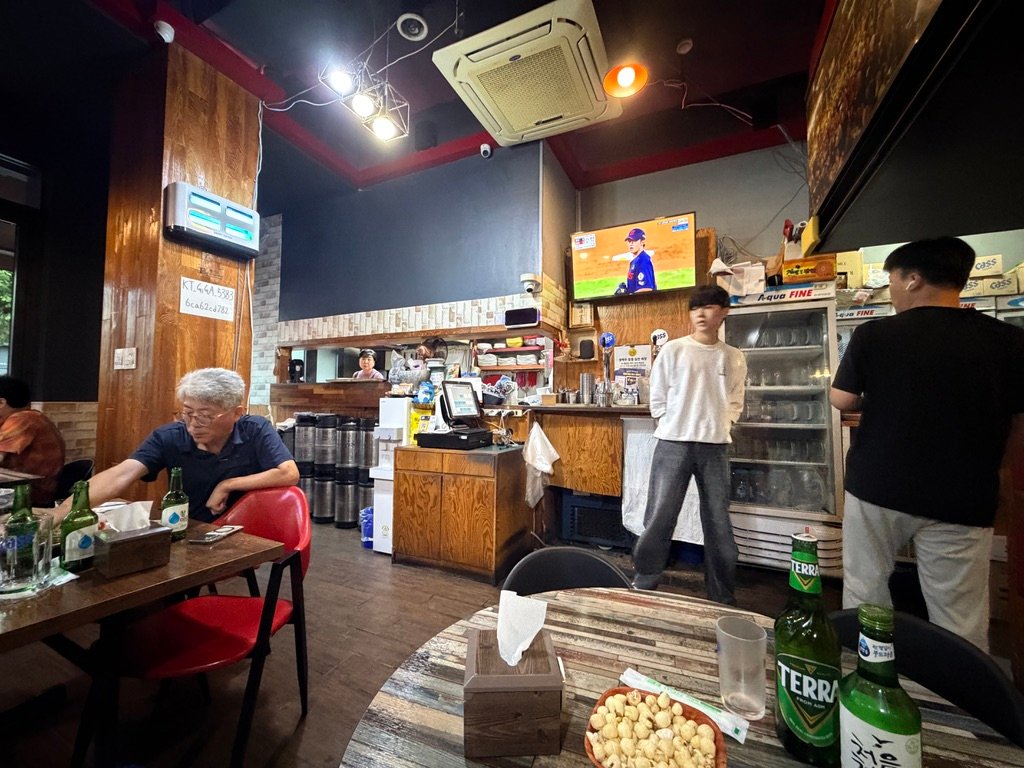 Brick-toned walls and red chairs inside Hook Chicken restaurant