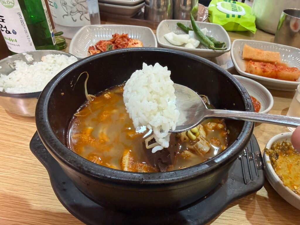 Stone bowl of haejangguk with rice stirred into the broth