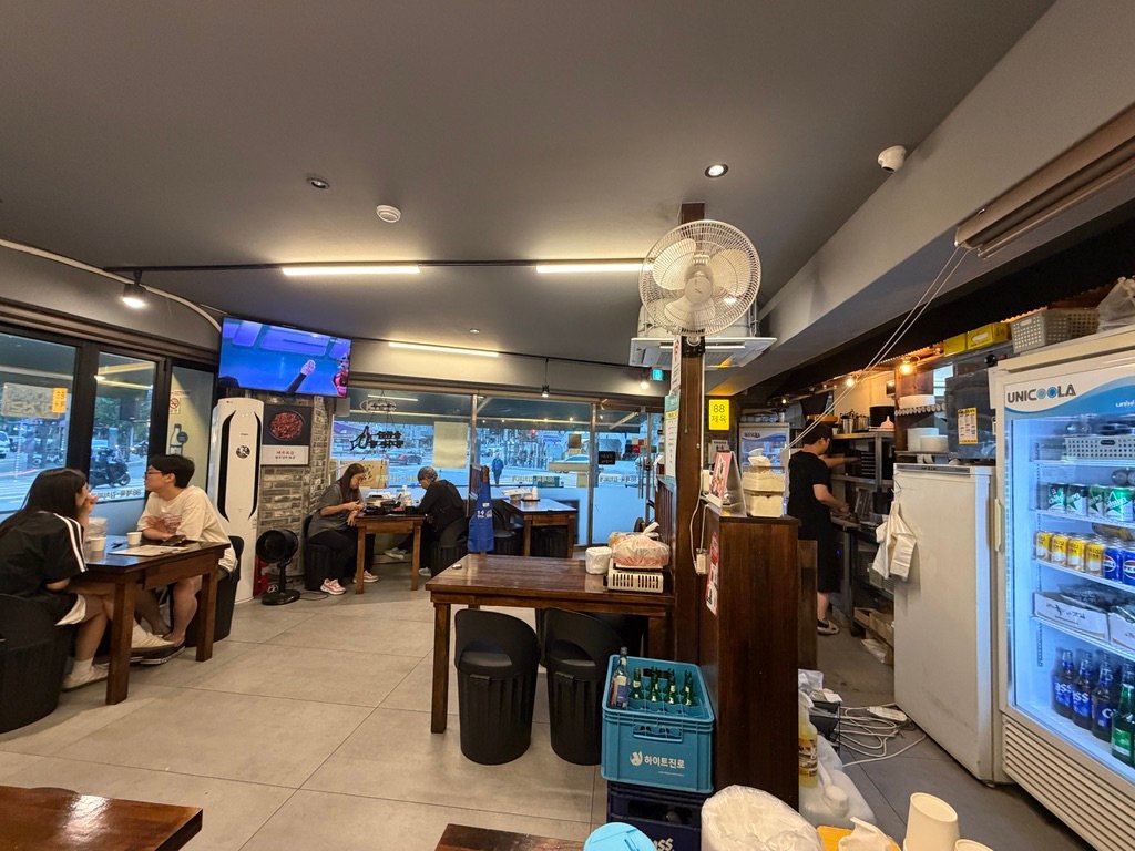 Interior of 88 Jeyuk Jangan Branch with wooden tables and black stools