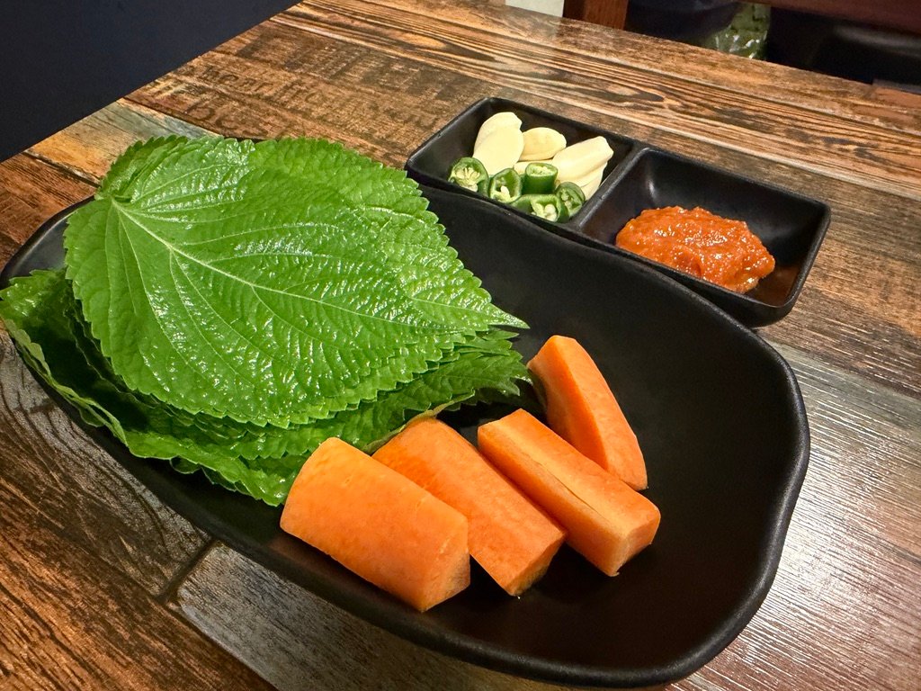 Perilla leaves, garlic, and green chili peppers served as banchan