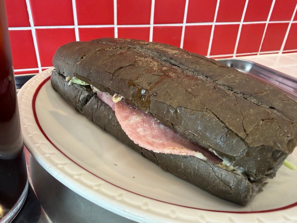 Close-up of jambon-beurre sandwich showing ham and butter filling