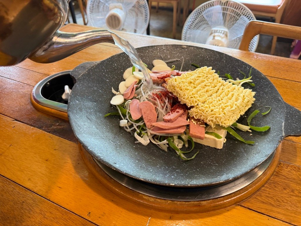 Ramyeon noodles added to budae-jjigae broth
