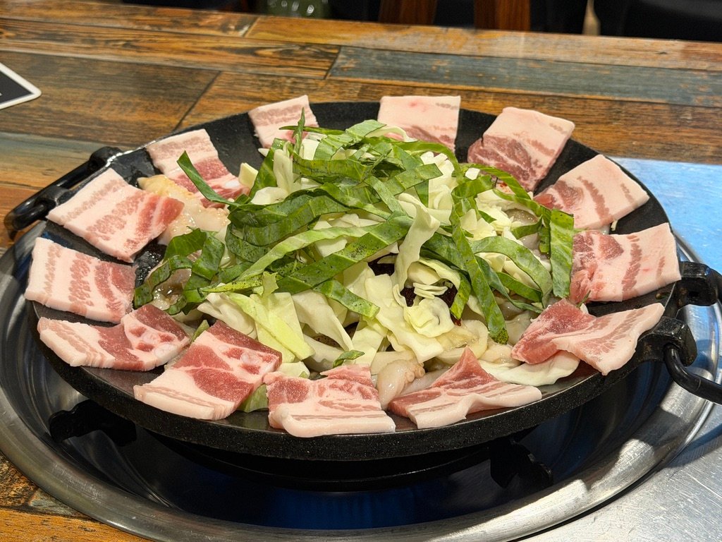 Chukkumi and vegetables cooking in spicy red sauce on a griddle
