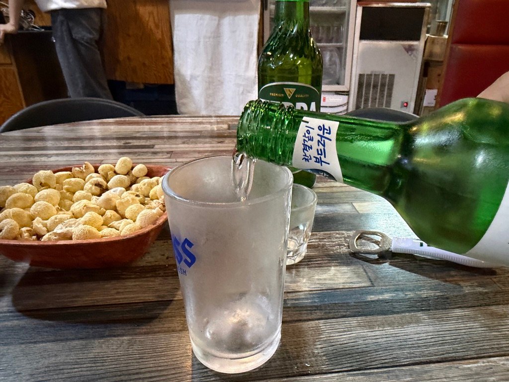 Bottle of soju and two bottles of beer on the table