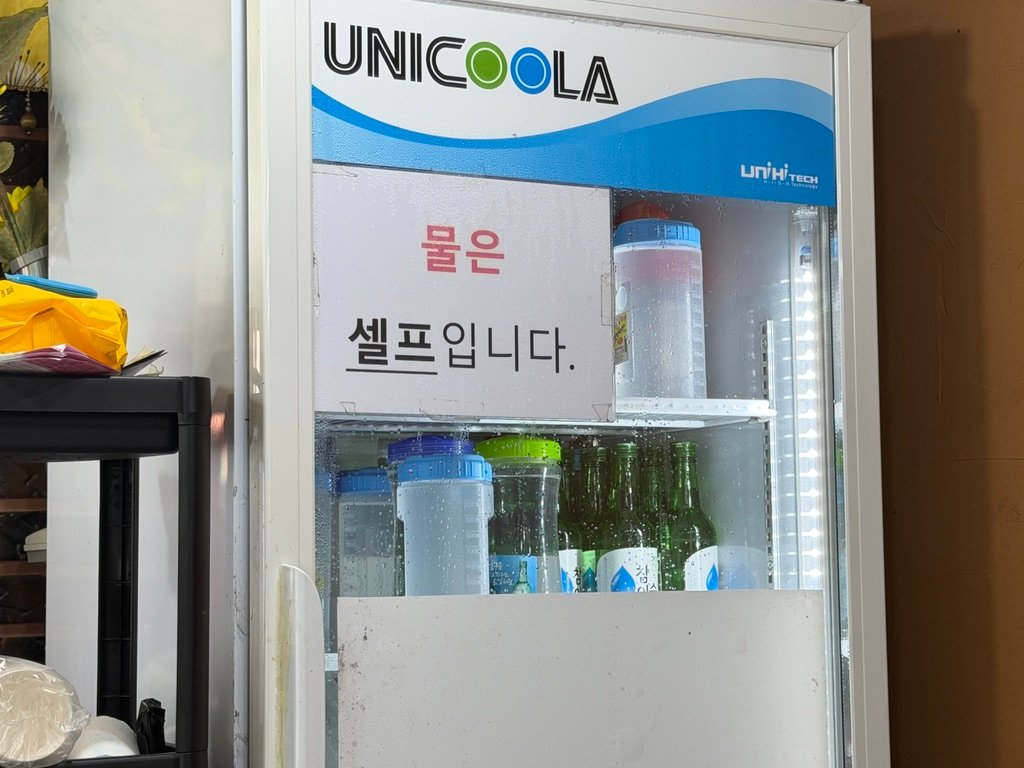 Self-serve water and drinks refrigerator inside a Korean restaurant