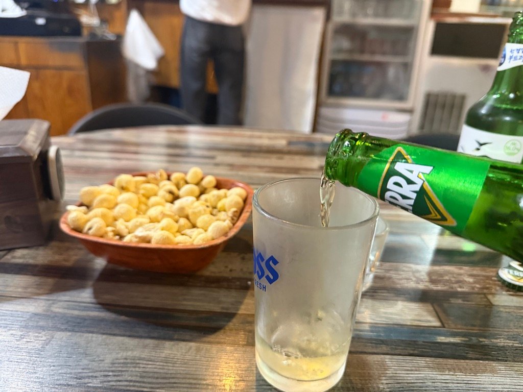 Soju and beer poured into glasses at Hook Chicken