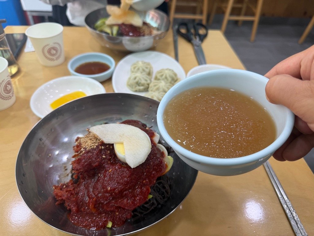 ide broth poured over bibim-naengmyeon to soften the spice