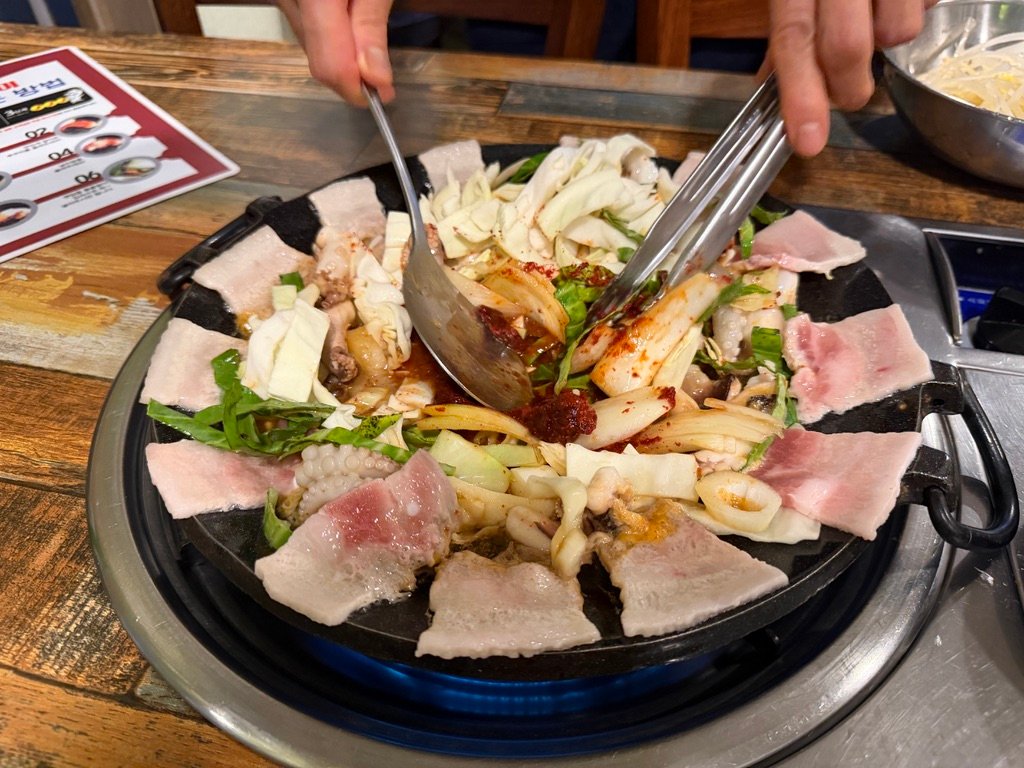 Close-up of spicy baby octopus bubbling in sauce on the grill