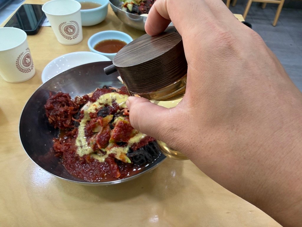 ide broth poured over bibim-naengmyeon to soften the spice