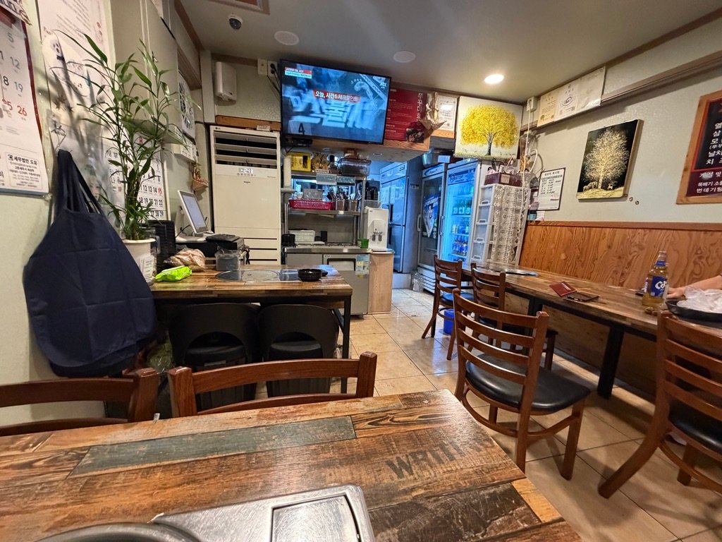 Interior seating at Yeoljeong Chukkumi with wood-toned tables